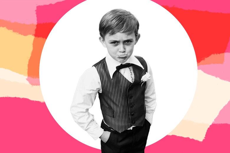 A little kid looking upset in a wedding suit.