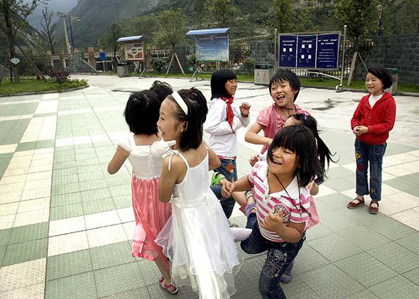 A group of girls plays a game at Xingxing primary school on June