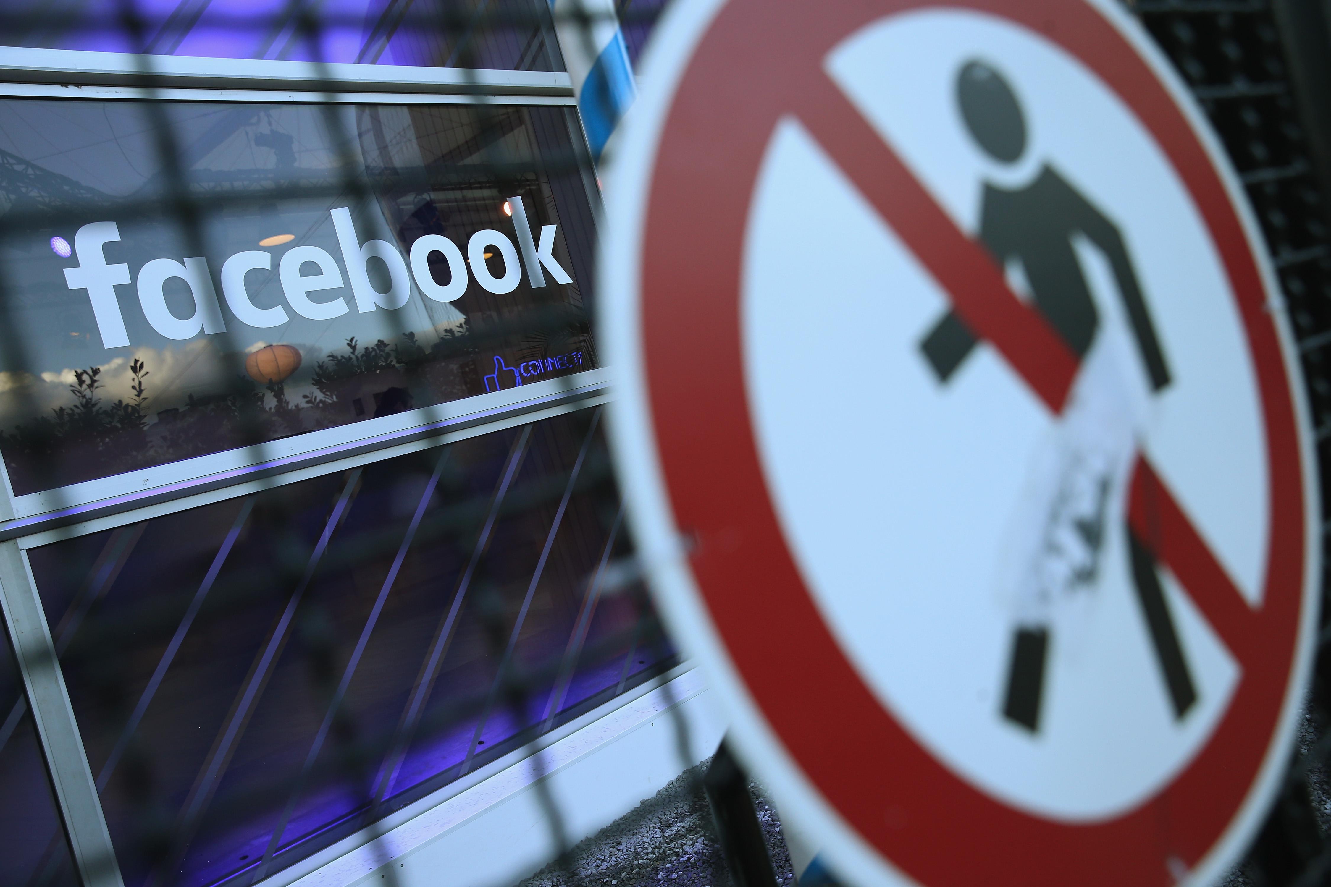 A no entry symbol hangs on an opened gate next to the Facebook logo at the Facebook Innovation Hub on Feb. 24, 2016 in Berlin.