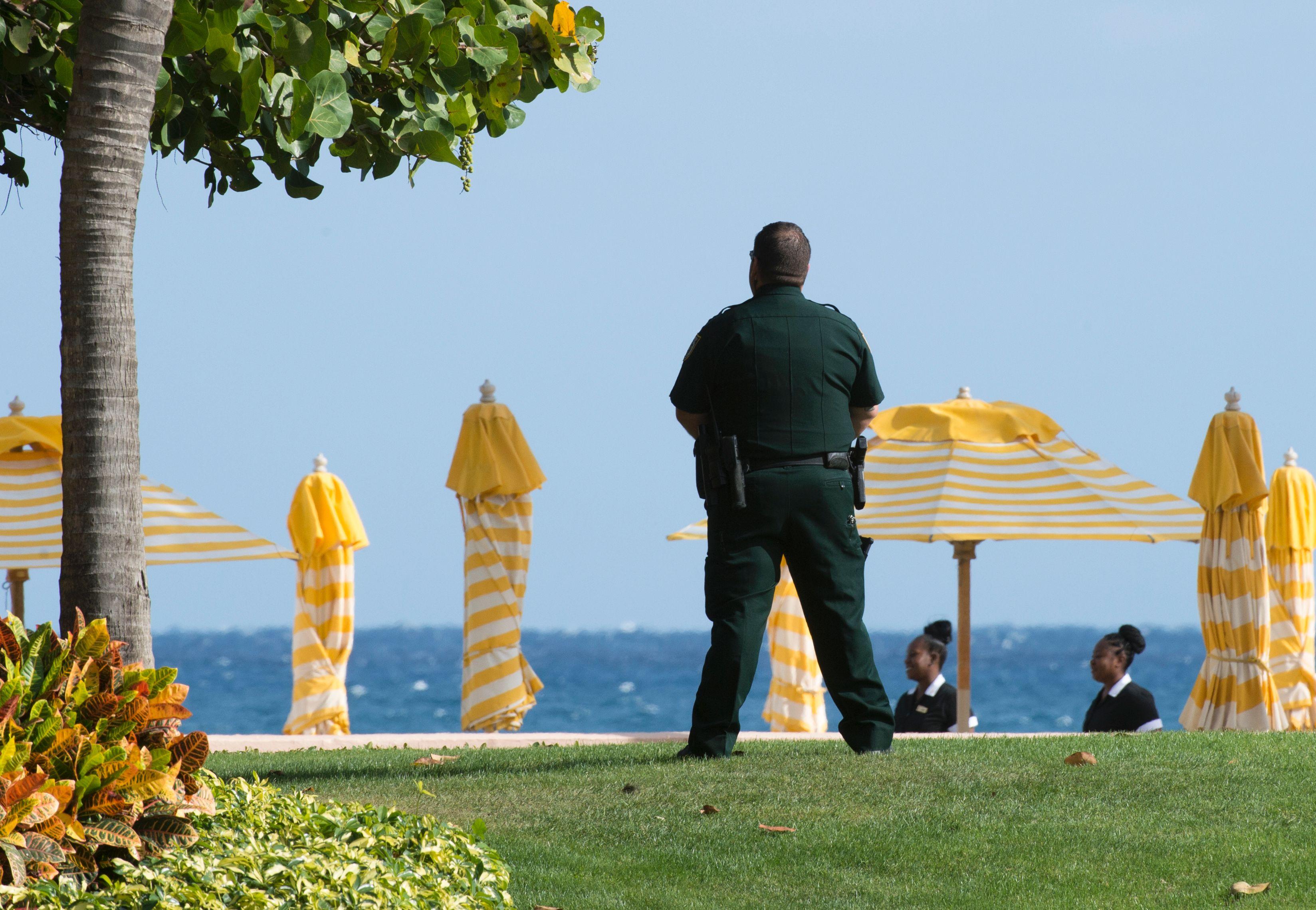 The guard is seen from behind facing a set of beach umbrellas.