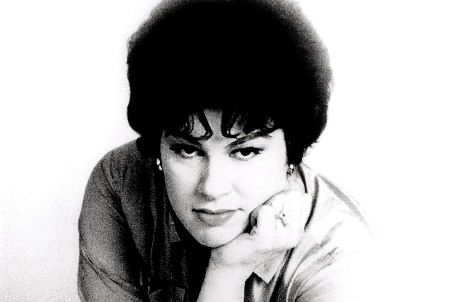 Patsy Cline leaning forward with her chin on her hand.