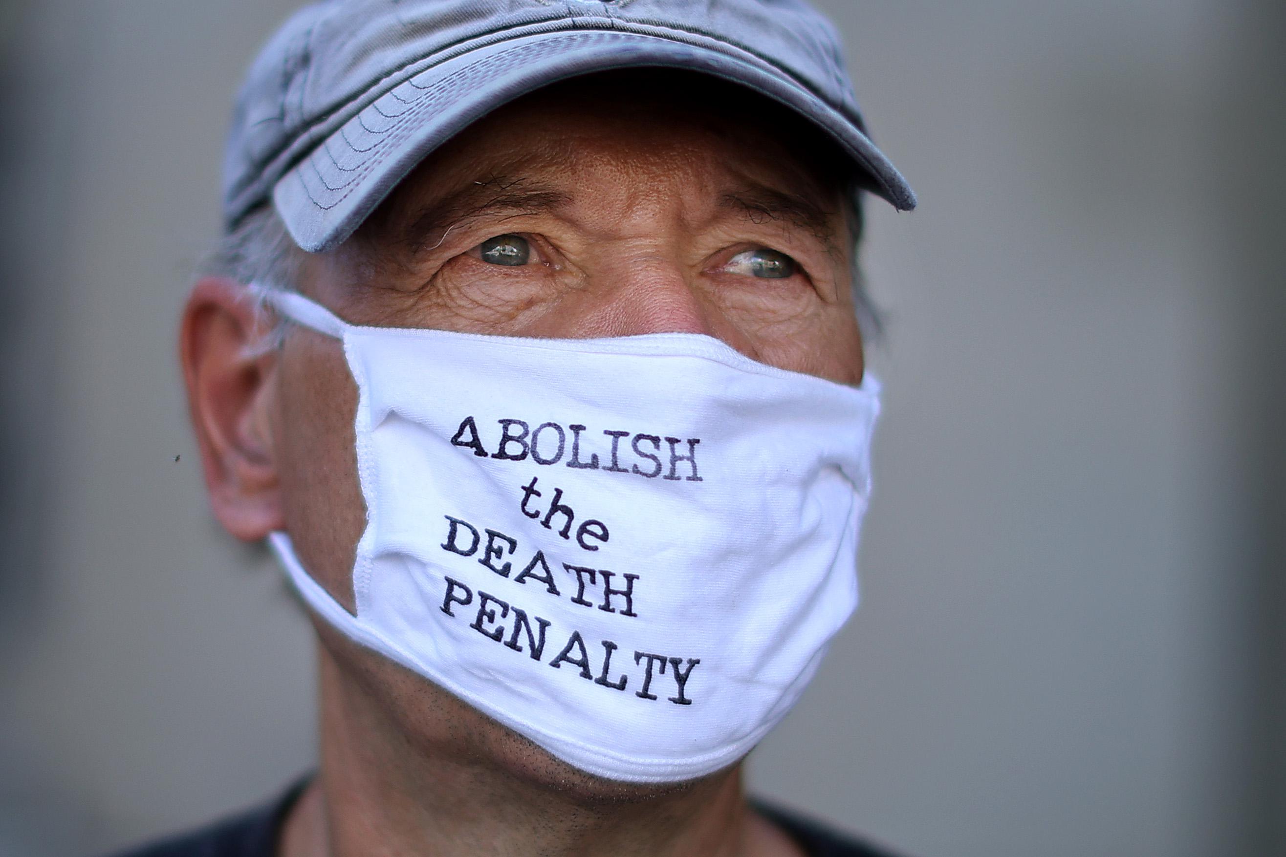 Laffin stares deeply wearing a mask that says "Abolish the Death Penalty."