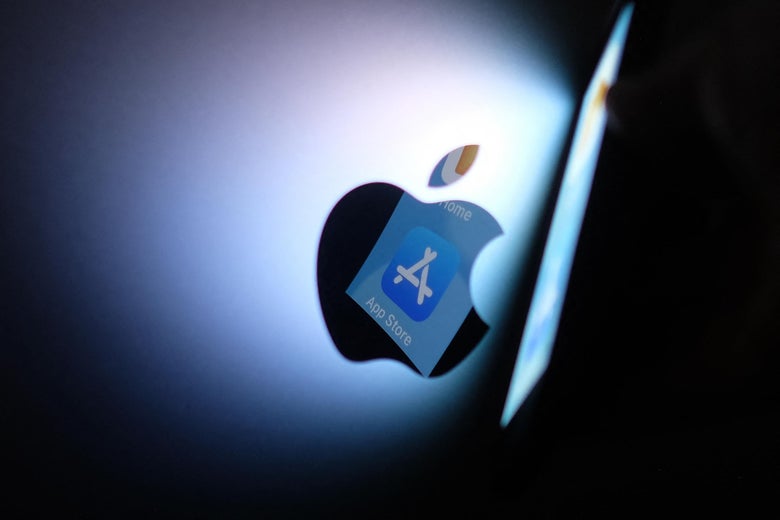 This illustration photo shows the Apple app store logo reflected from an iPhone onto the back of an iMac.