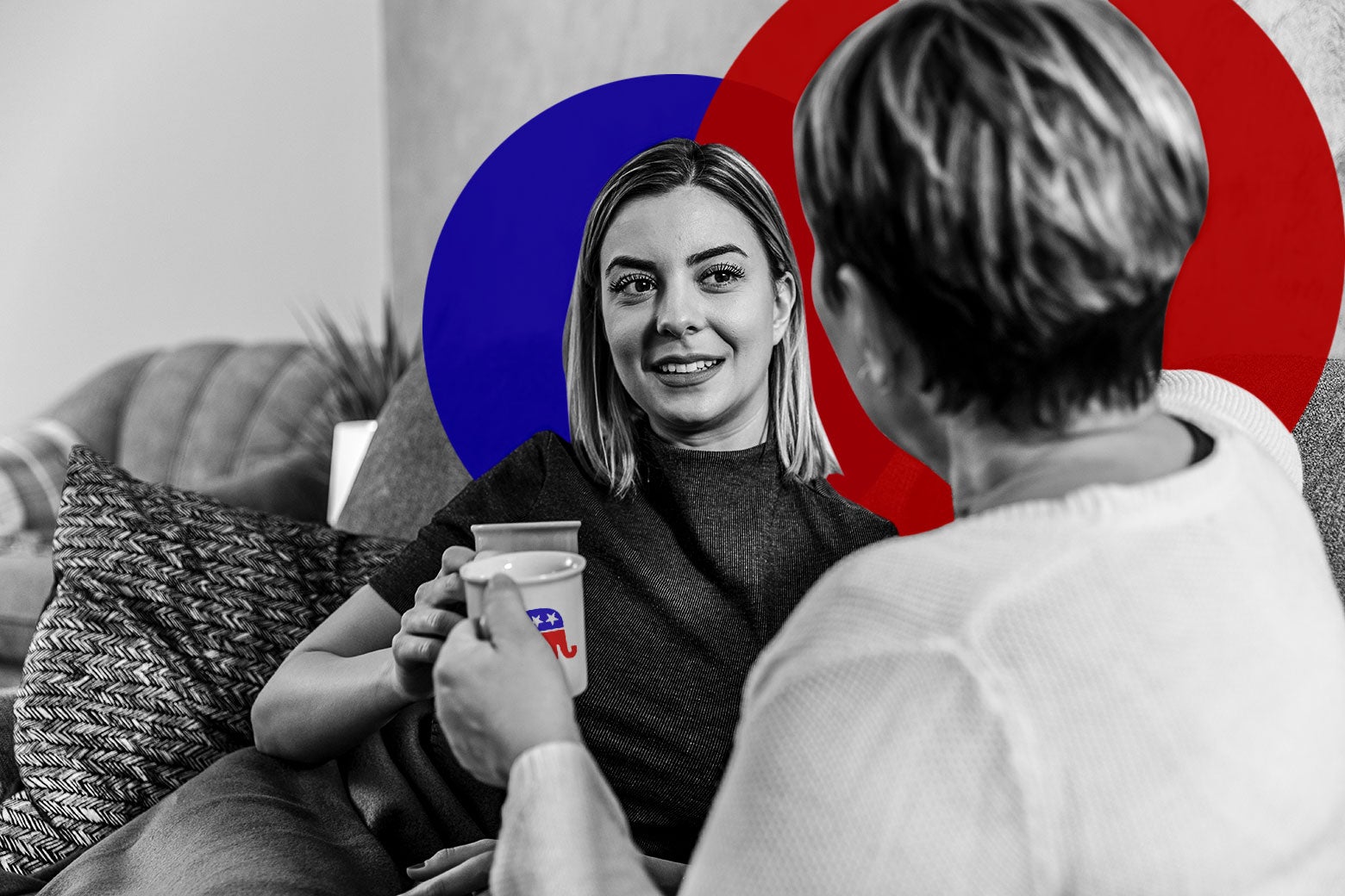 A younger woman sits on a couch drinking coffee with an older woman, seen from behind. The older woman is drinking out of a mug with a GOP elephant on it.