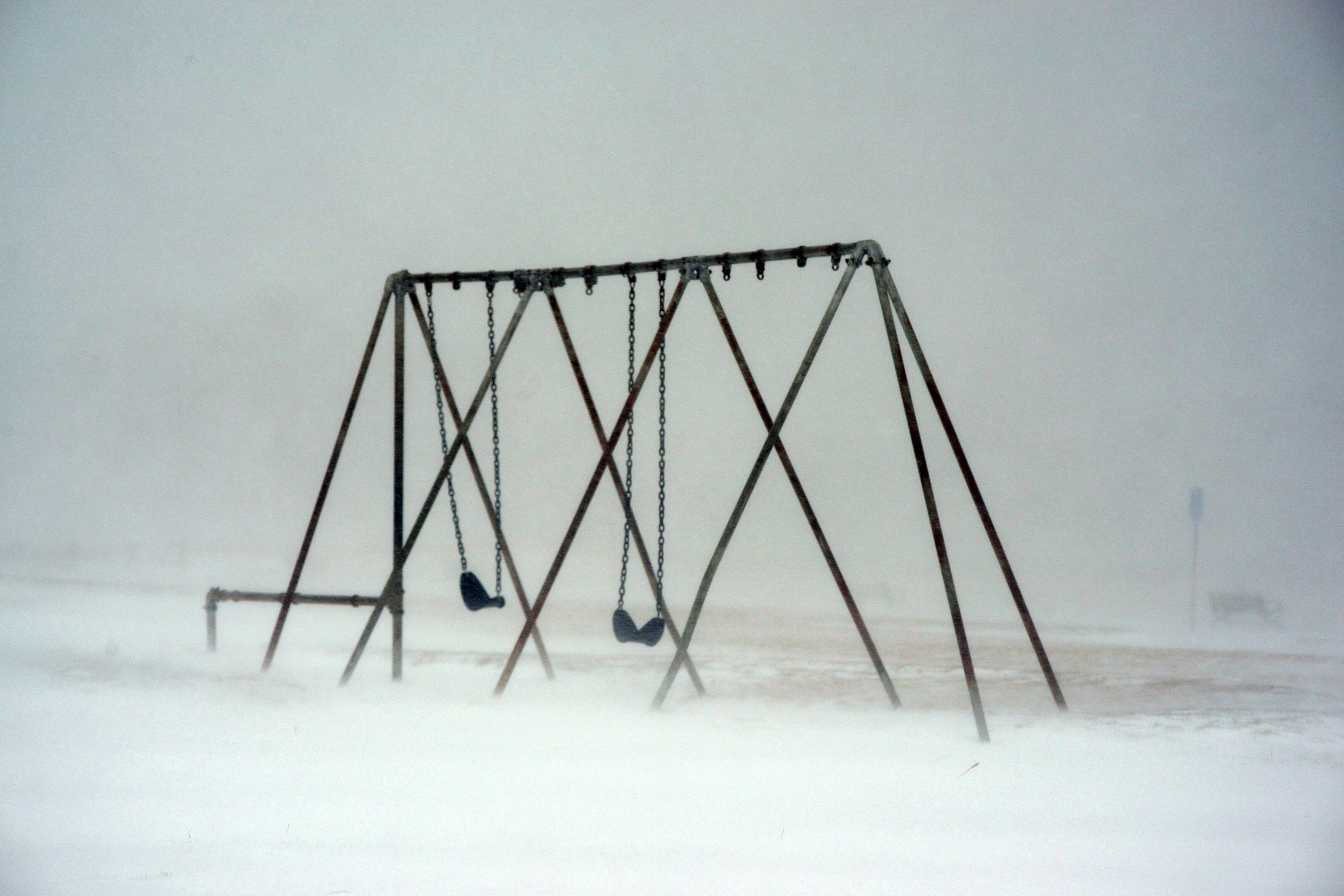 A swing set covered in snow.