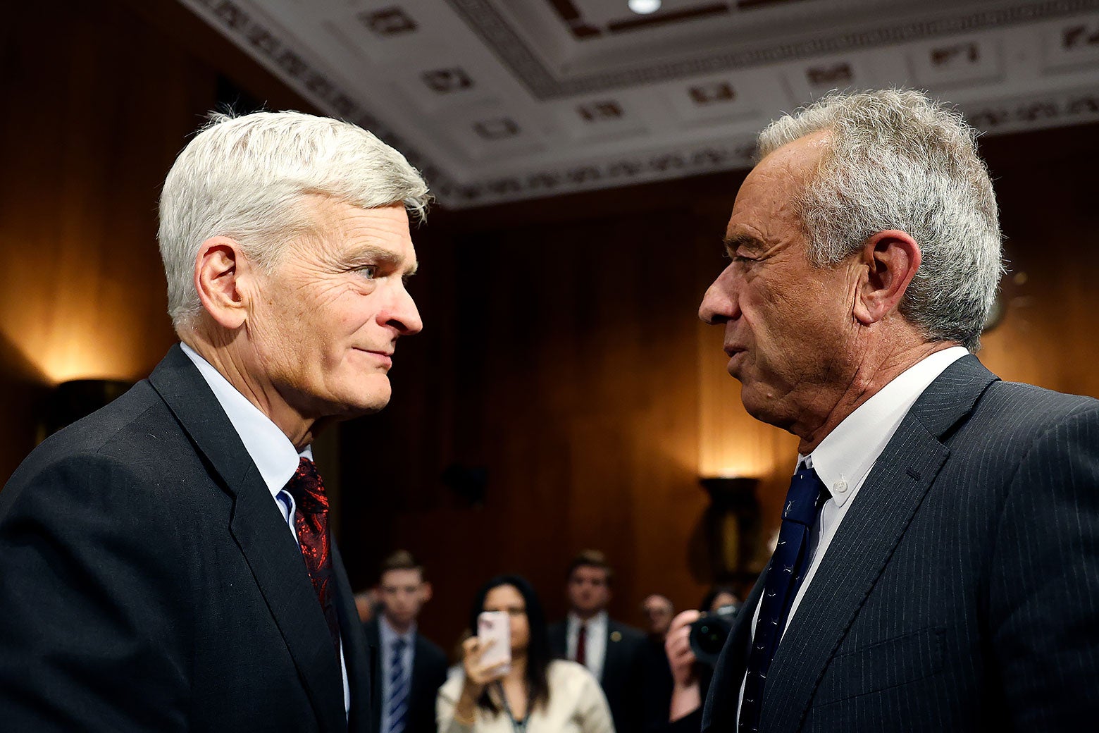 Sen. Bill Cassidy stands face-to-face with Robert F. Kennedy Jr. in a Senate hearing room.