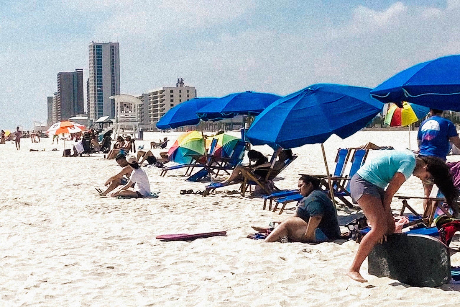 Vacationers sit on the beach