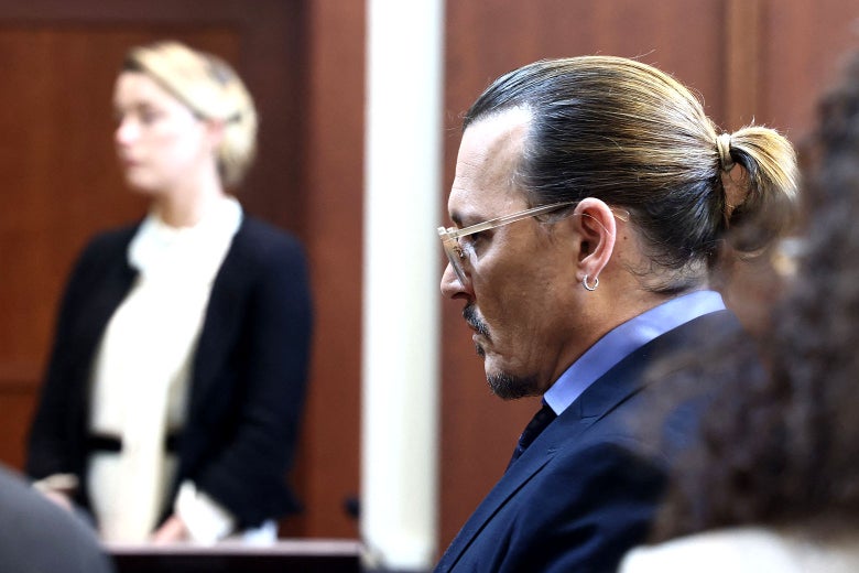 Johnny Depp in the foreground, Amber Heard in the background out of focus. 