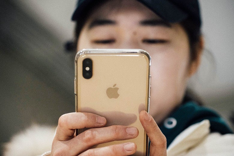 A woman looks at an iPhone.