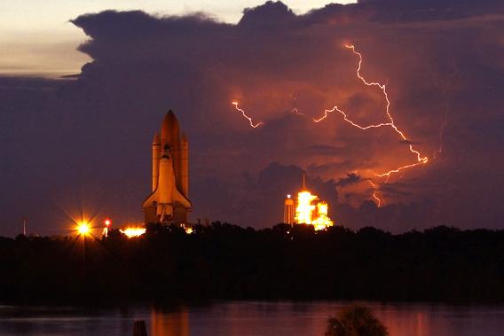 The space shuttle Discovery rolls out to Launch Pad 39A with lightning in the area at NASA's Kennedy Space Center in Cape Canaveral, Florida.