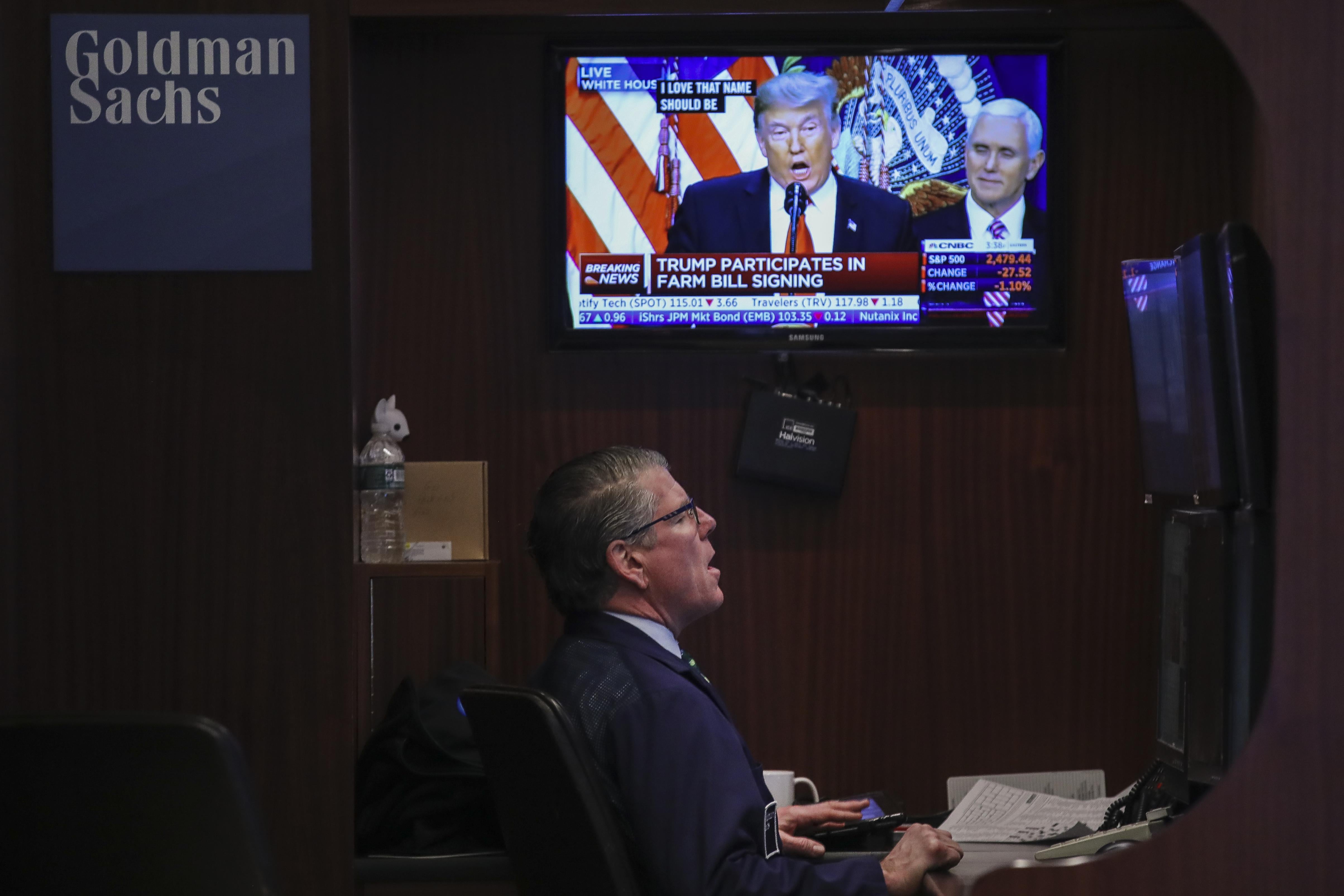 President Donald Trump is displayed on a monitor as a trader works at his desk ahead of the closing bell on the floor to he New York Stock Exchange (NYSE) on December 20, 2018 in New York City.