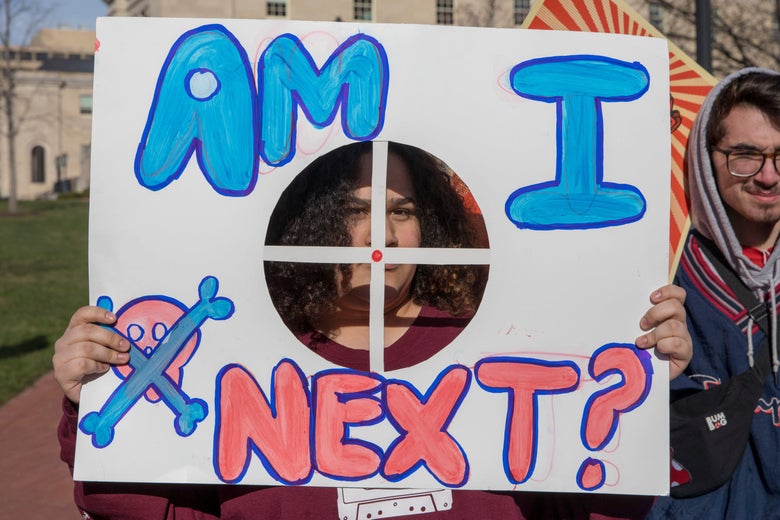 A protest sign reads, "Am I next?"