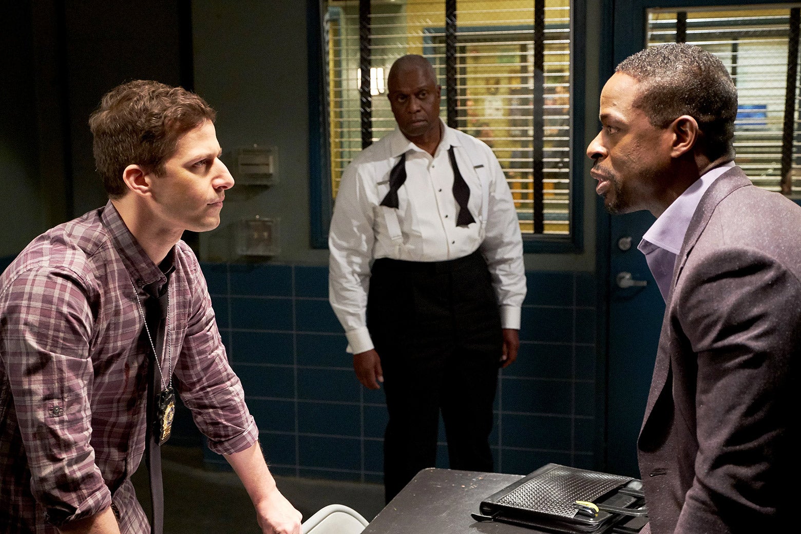 Andy Samberg intensely questions Sterling K. Brown, while Andre Braugher looks on.