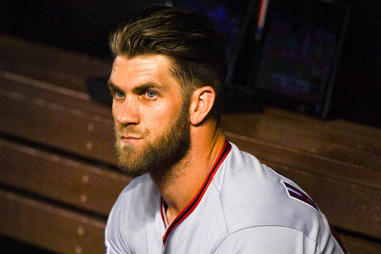 Bryce Harper sits in the dugout.