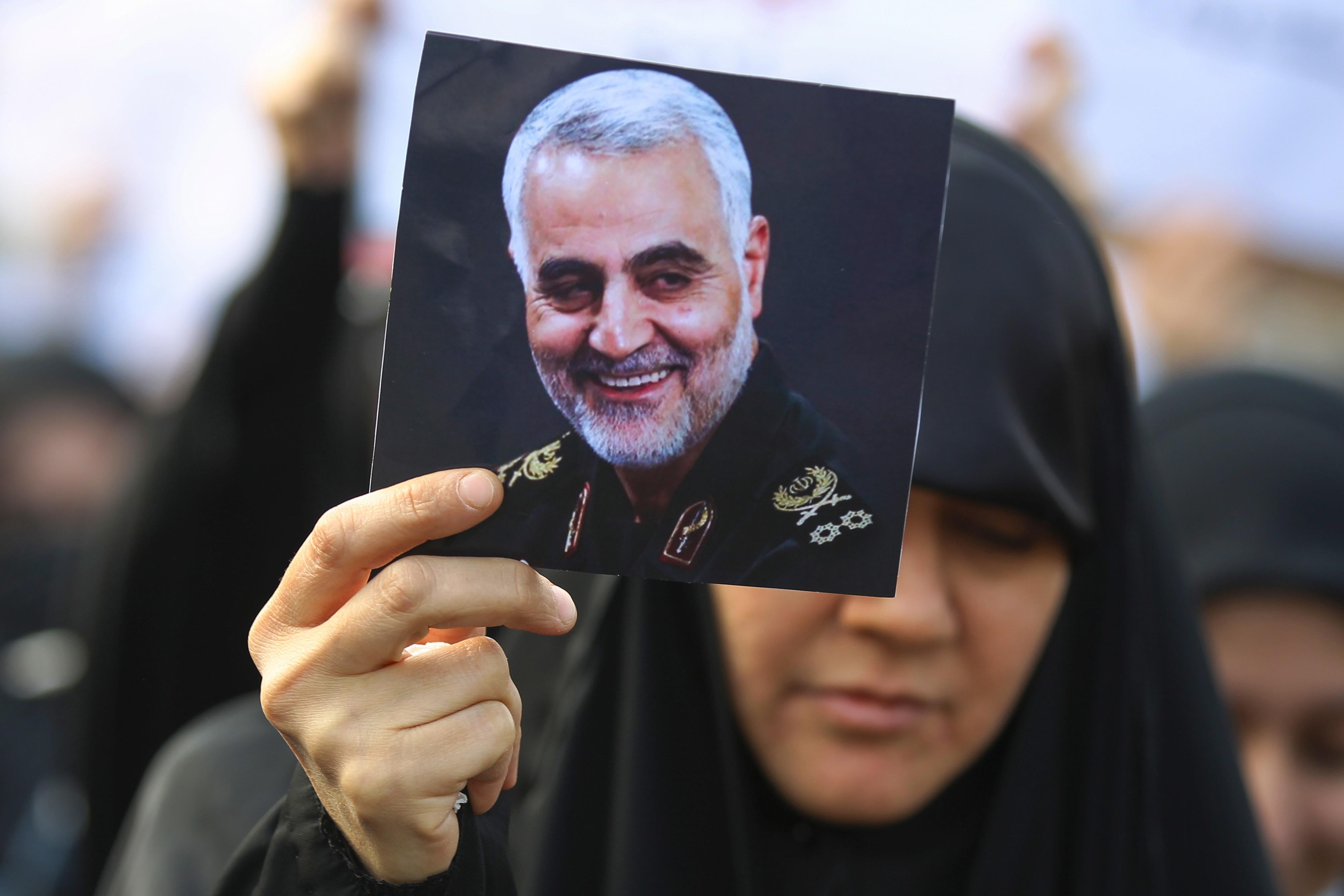 An Iraqi woman attends the funeral of Iranian military commander Qasem Soleimani (portrait), Iraqi paramilitary chief Abu Mahdi al-Muhandis and eight others in Baghdad's district of al-Jadriya, in Baghdad's high-security Green Zone, on January 4, 2020.