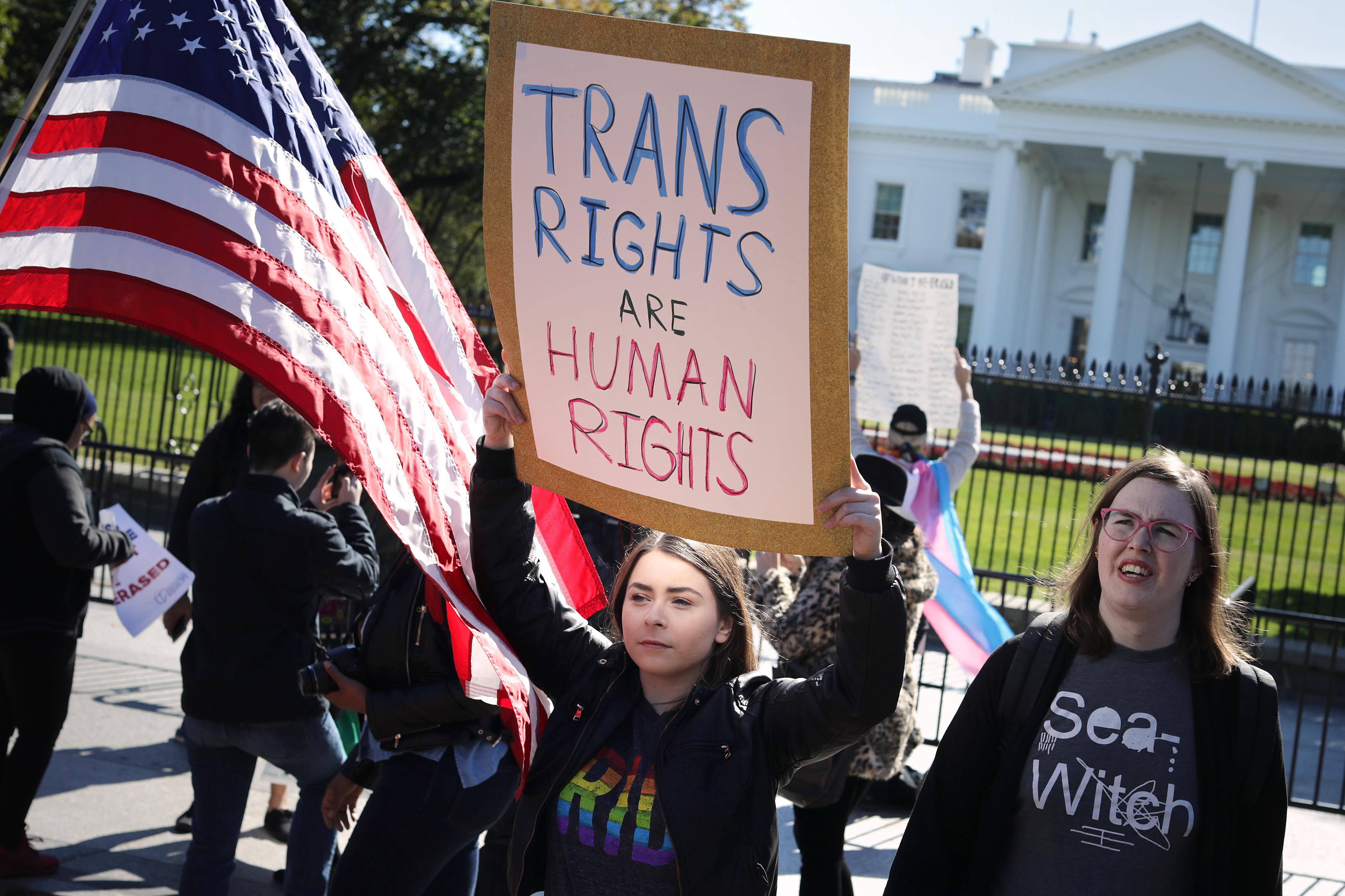 A protester carries a "trans rights are human rights" sign at a transgender rights rally in front of the White House.