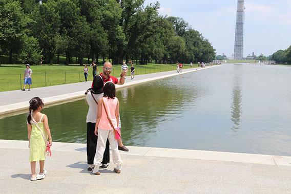 Tourists from Kuwait photograph Dad squishing the Washington Monument.