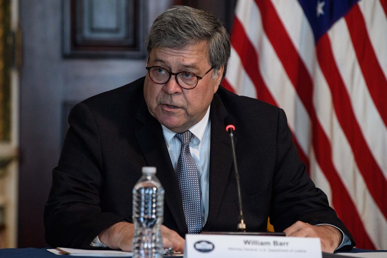 Barr seated, talking in front of a mic