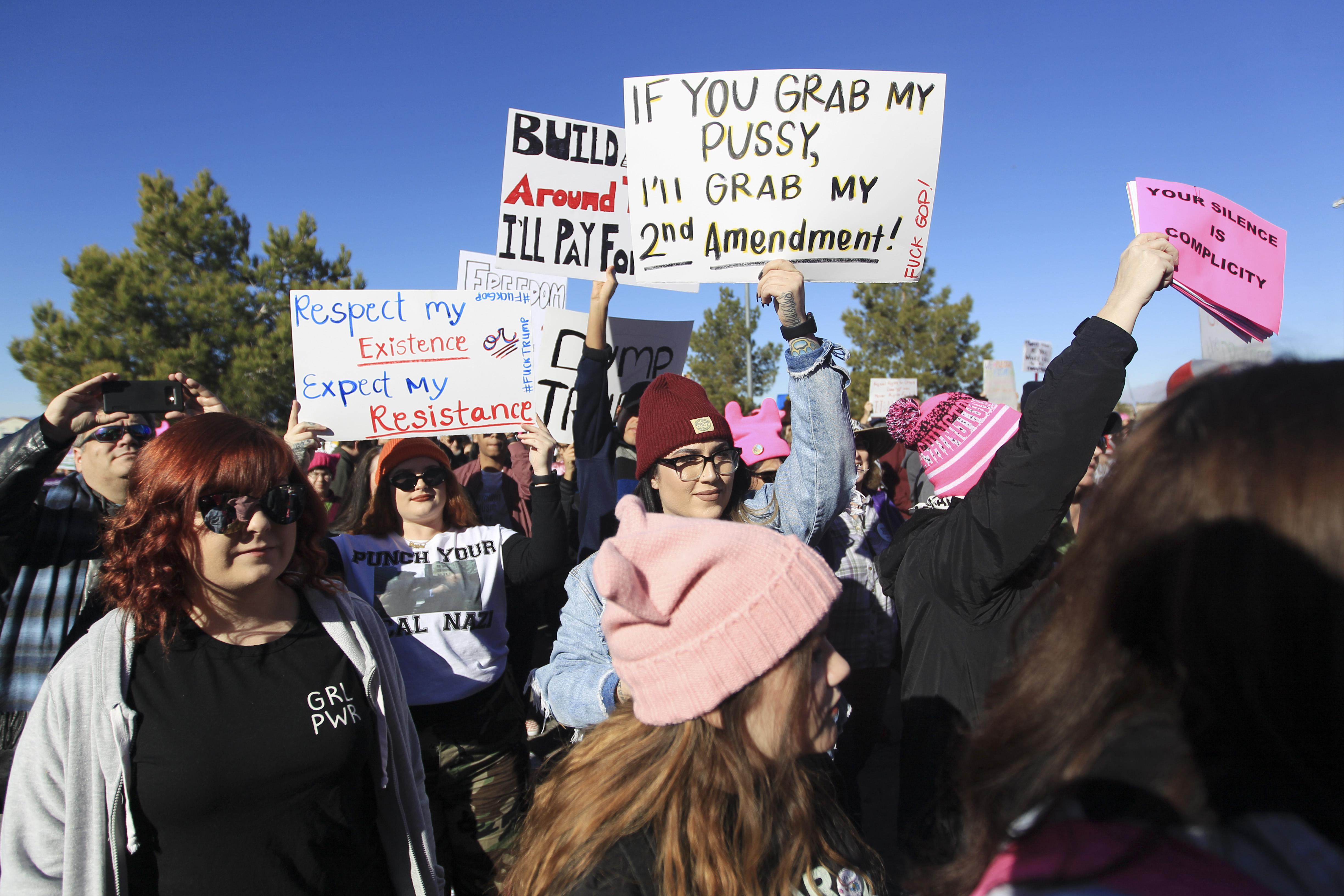 Protesters carry signs as they make their way to Sam Boyd Stadium for the Women's March 'Power to the Polls' voter registration tour launch on January 21, 2018, in Las Vegas, Nevada. Demonstrators across the nation gathered over the weekend, one year after the historic Women's March on Washington, D.C., to protest President Donald Trump's administration and to raise awareness for women's issues.
