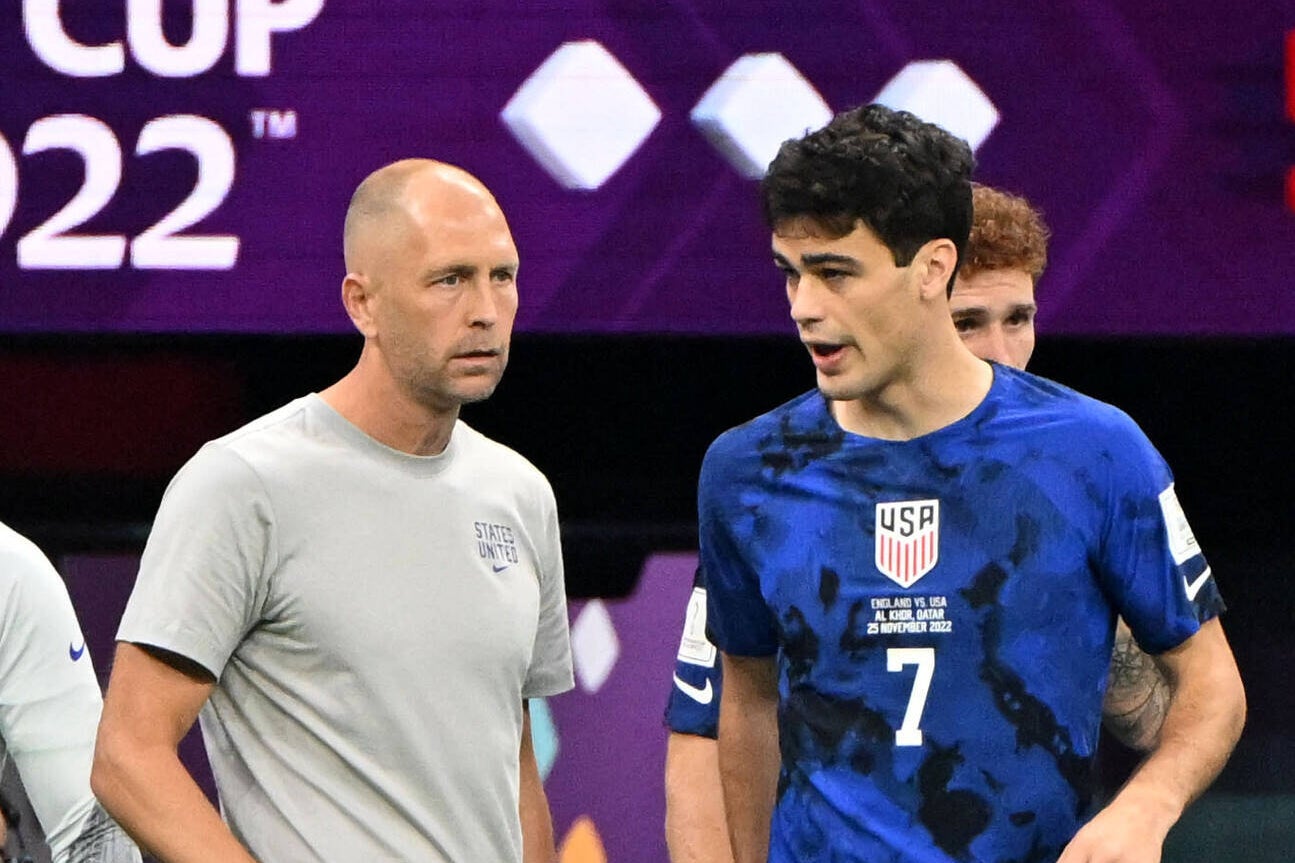 Gregg Berhalter and Gio Reyna speaking in the tunnel of a stadium in Qatar at the World Cup