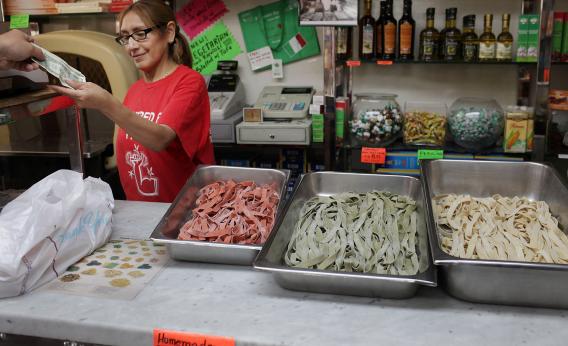 Elizabeth Amaros stands near trays of fresh pasta at Piemonte Ravioli on June 15, 2011, in New York City.