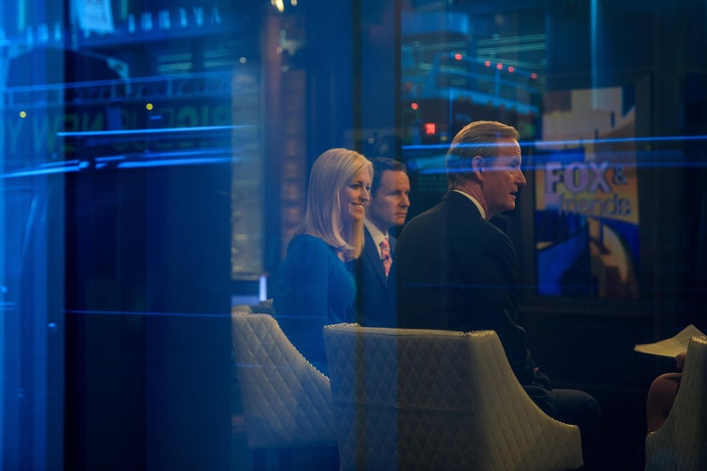 Seen through a window, (L to R) hosts Ainsley Earhardt, Brian Kilmeade and Steve Doocy broadcast 'Fox And Friends' from the Fox News studios, February 17, 2017 in New York City. President Trump, a frequent consumer and critic of cable news, recently tweeted that Fox and Friends is 'great'. (Photo by Drew Angerer/Getty Images)