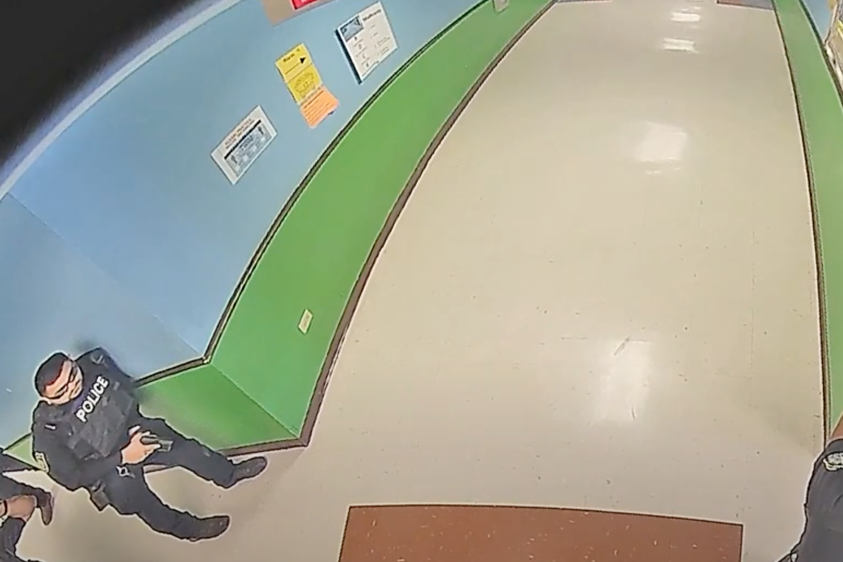 Footage from the video obtained by the Austin American-Statesman and KVUE. An officer stands with a gun pointed down a hallway of an Elementary School.