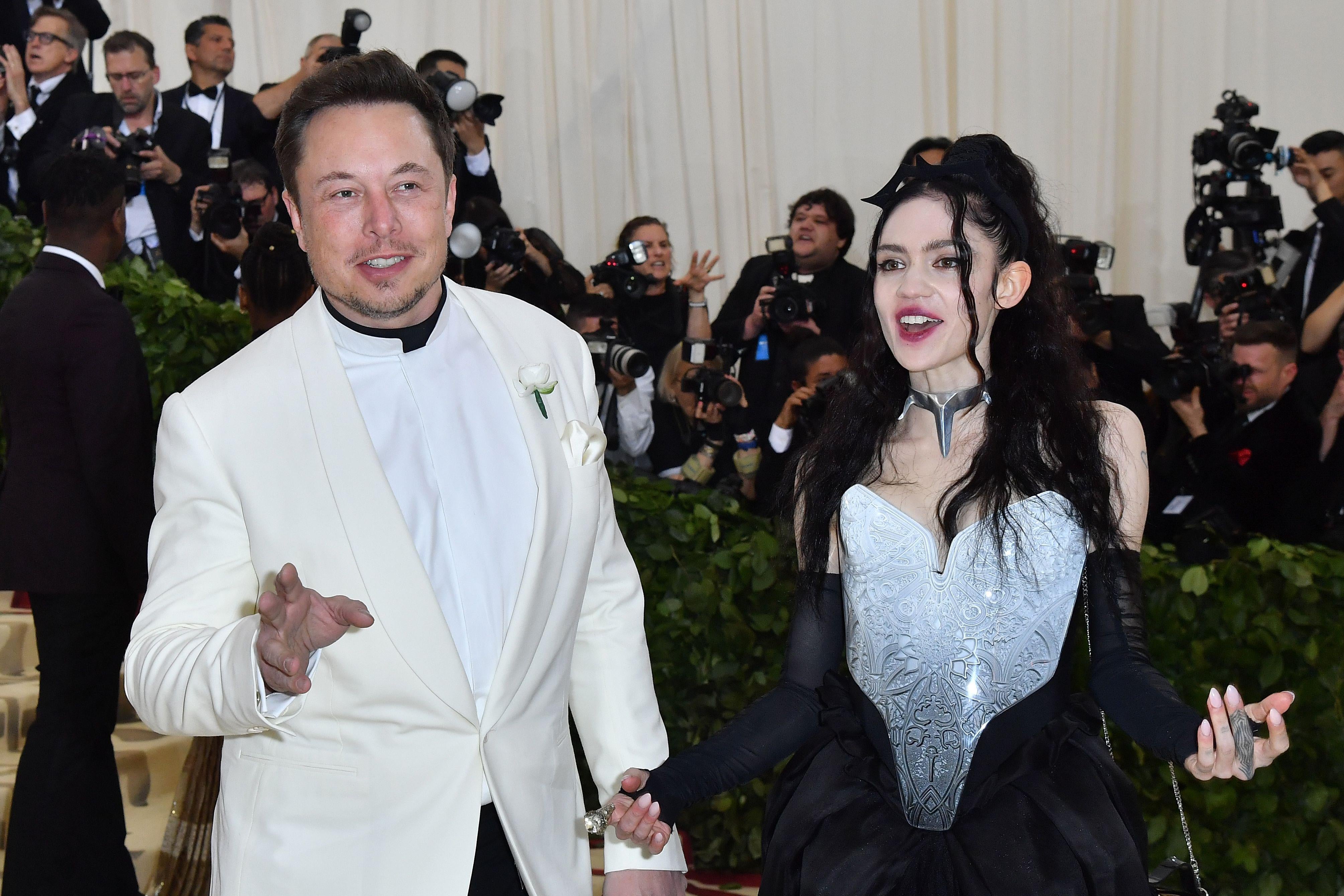 Elon Musk and Grimes arrive for the 2018 Met Gala on May 7, 2018, at the Metropolitan Museum of Art in New York. - The Gala raises money for the Metropolitan Museum of Arts Costume Institute. The Gala's 2018 theme is Heavenly Bodies: Fashion and the Catholic Imagination. (Photo by ANGELA WEISS / AFP)        (Photo credit should read ANGELA WEISS/AFP/Getty Images)