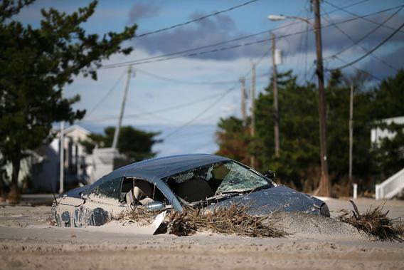 A car is buried in sand that was washed in from Hurricane Sandy on October 31, 2012 in Long Beach Island, New Jersey.