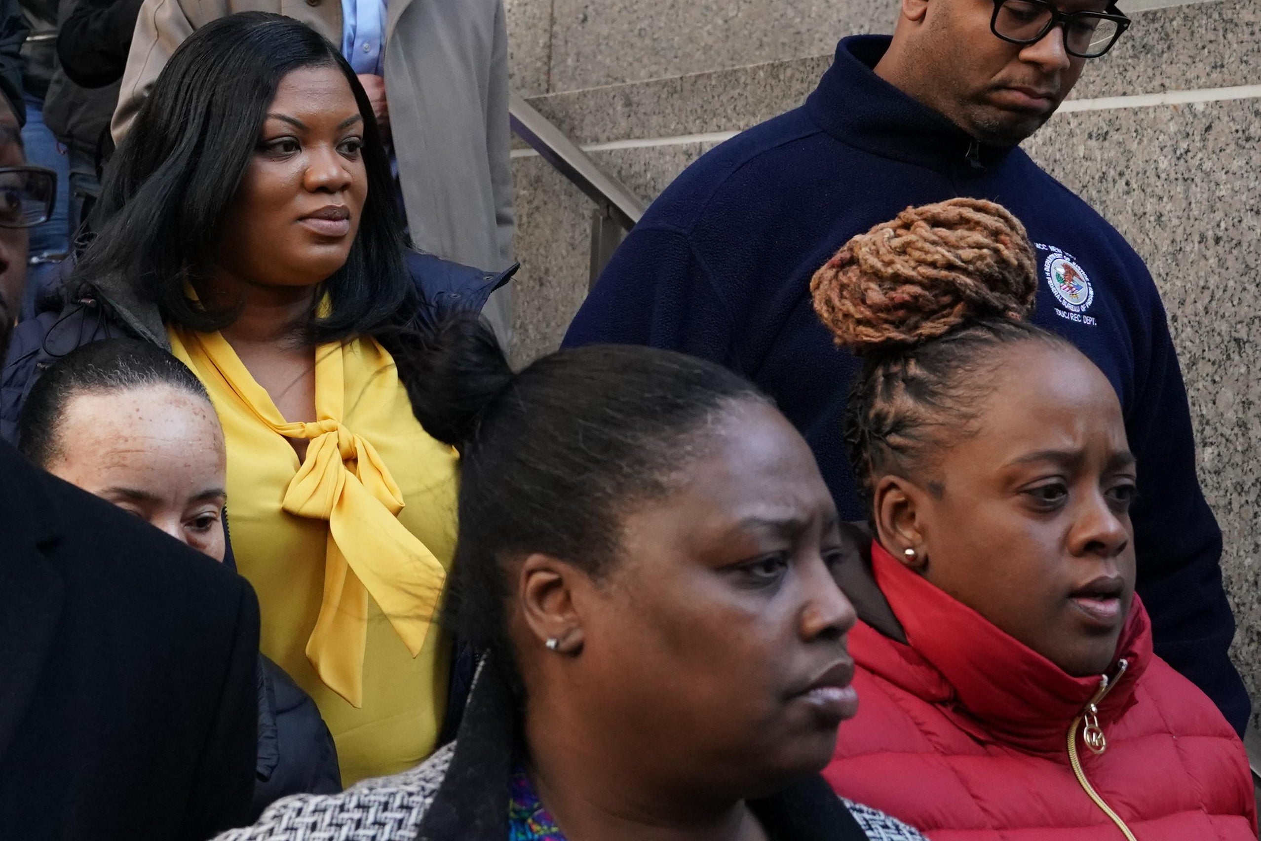 Metropolitan Correctional Center guard Tova Noel (yellow shirt) surrounded by supporters leaves Federal Court in New York City on November 25, 2019. 