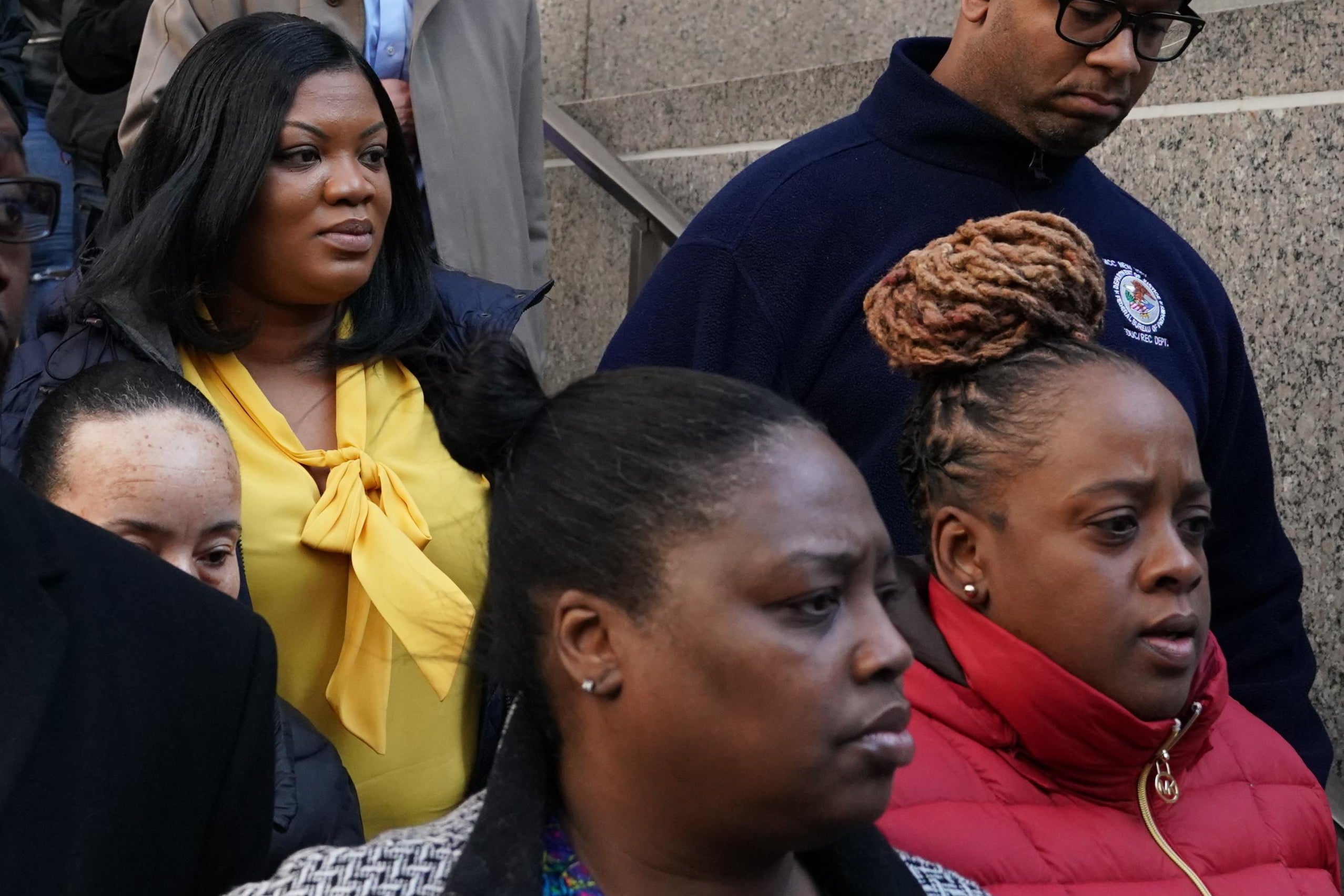 Metropolitan Correctional Center guard Tova Noel (yellow shirt) surrounded by supporters leaves Federal Court in New York City on November 25, 2019.