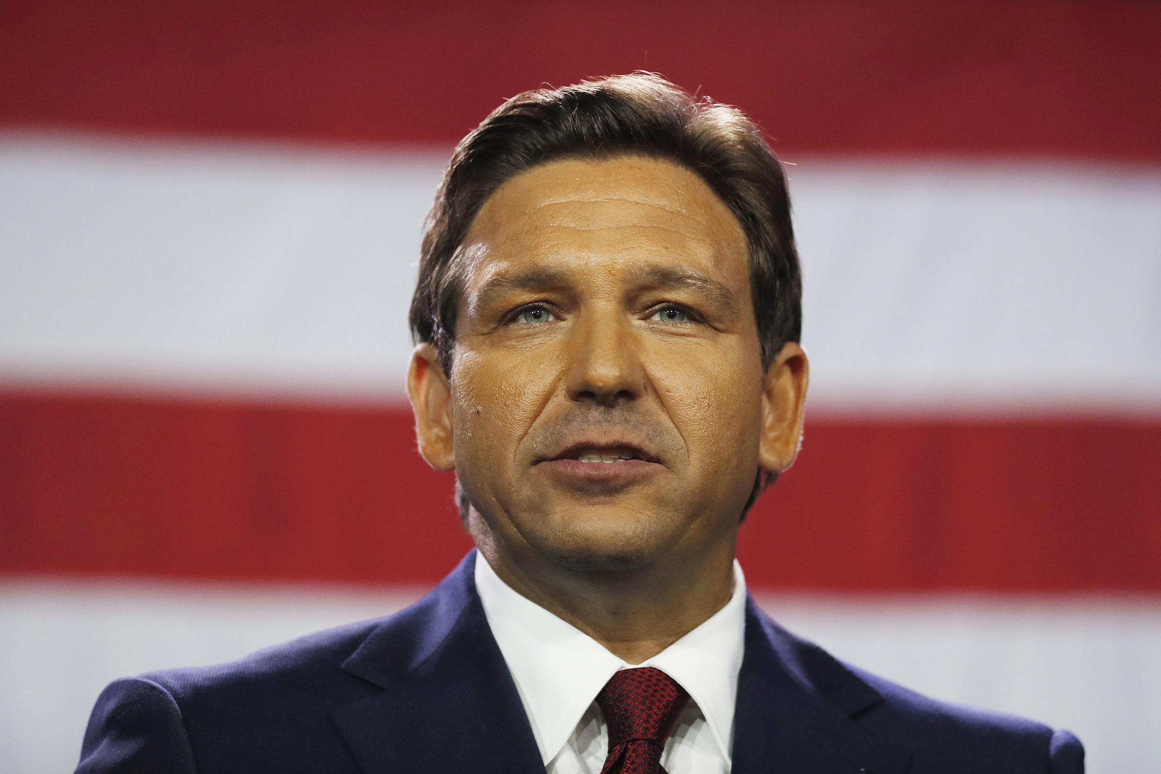 Ron DeSantis standing in front of an American flag. 
