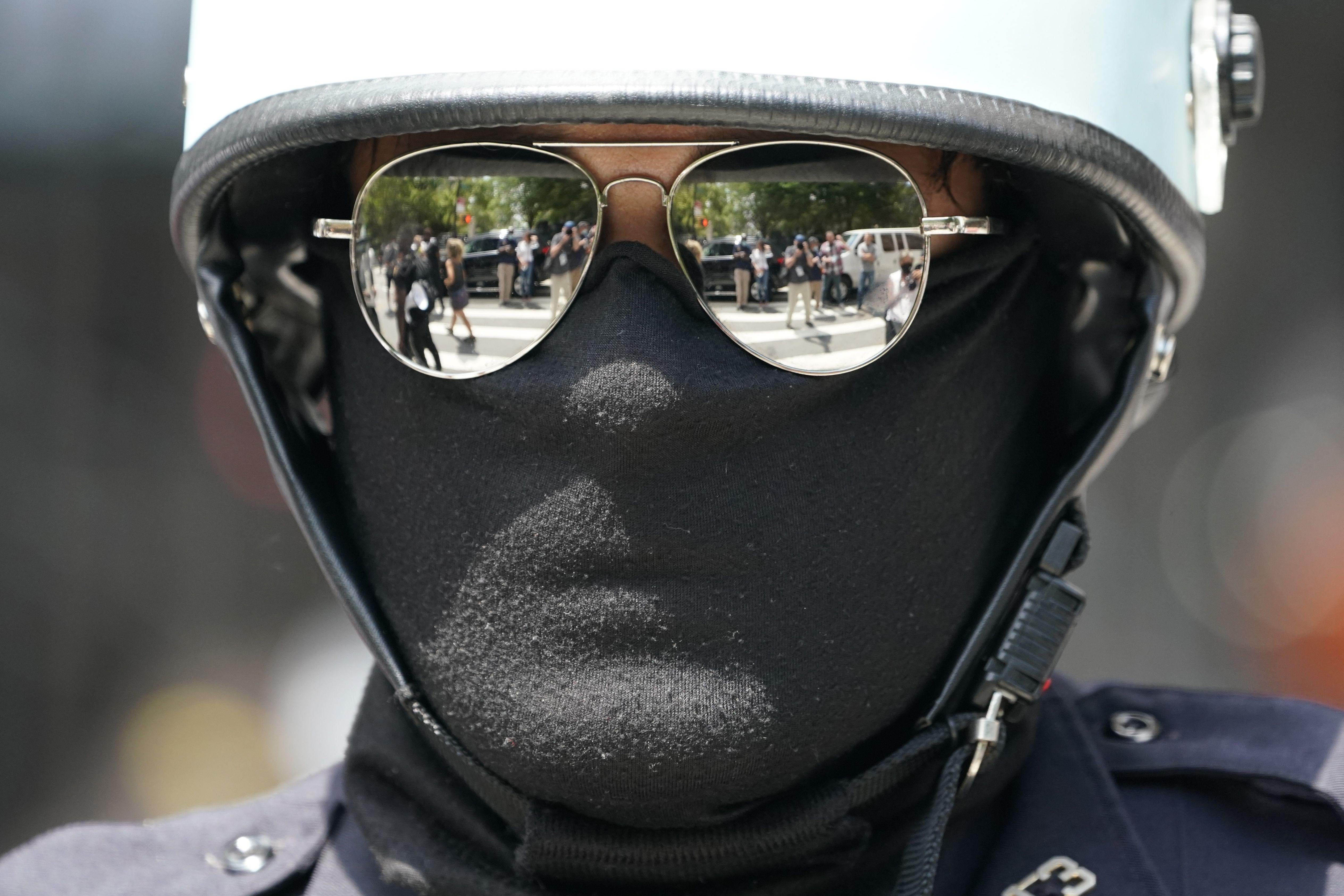 A man in a helmet, mask, and mirrored sunglasses wearing a mask that 