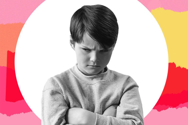 A young boy with his arms folded looking discontent.