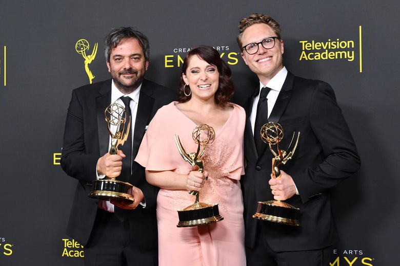 Adam Schlesinger, Rachel Bloom and Jack Dolgen pose with Emmys on a red carpet.