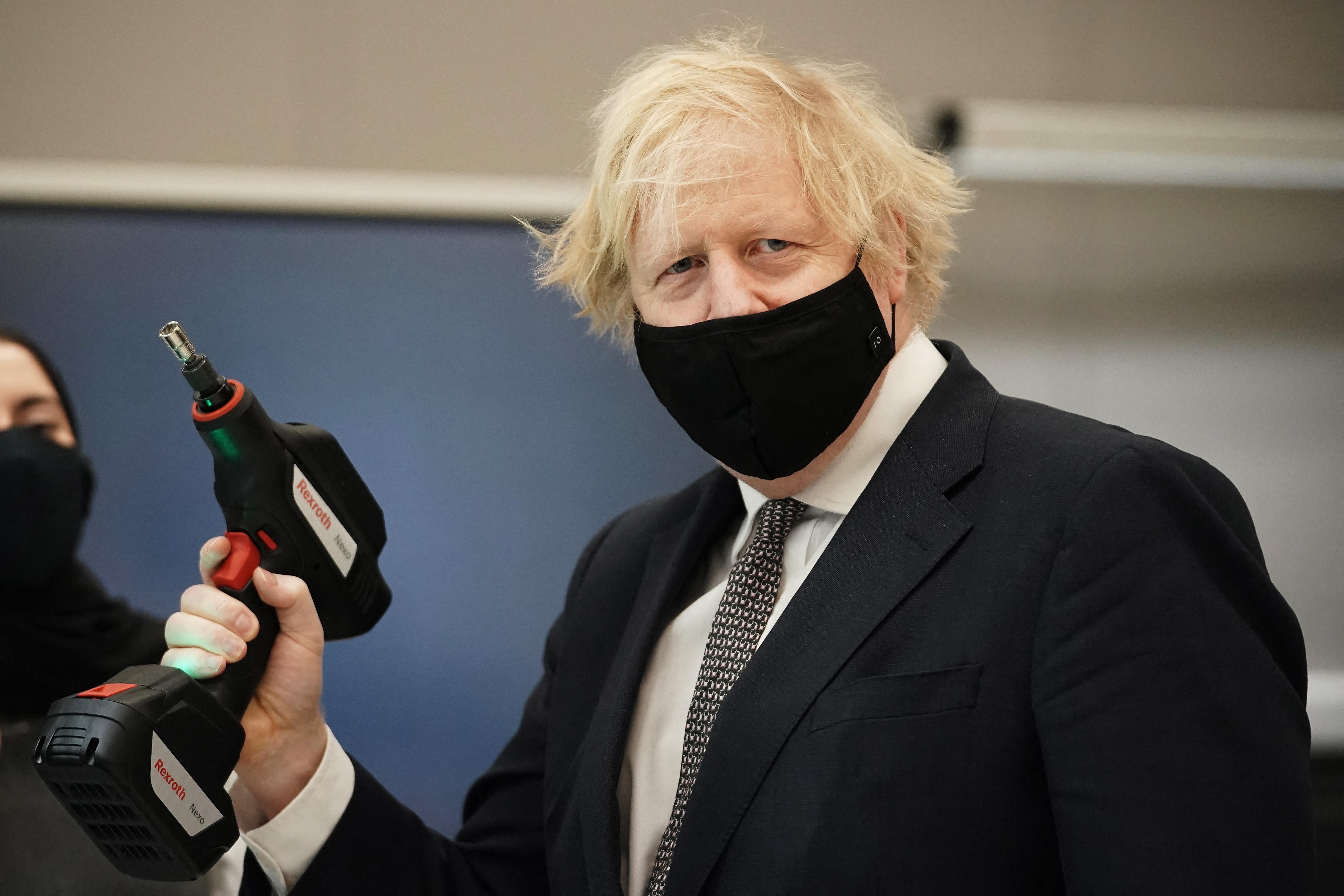 Boris Johnson holding a power drill.