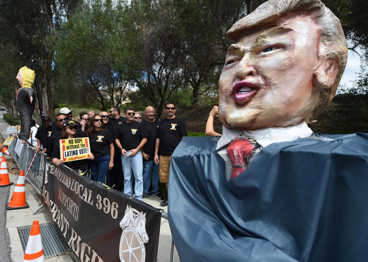 Latinos Teamsters pose beside an effigy of Donald Trump during protests outside the GOP debate in Simi Valley, California, on Sept. 16, 2015.