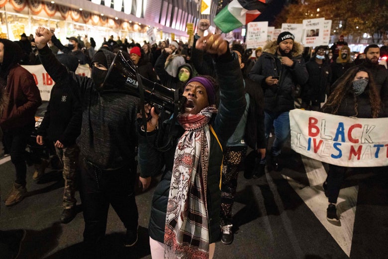 A demonstrator raises her fist while marching on the street during a protest against the Kyle Rittenhouse not-guilty verdict near the Barclays Center in New York on November 19, 2021.