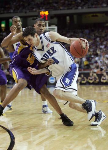 J.J. Redick #4 of the Duke Blue Devils dribbles against Garrett Temple #14 of the LSU Tigers.