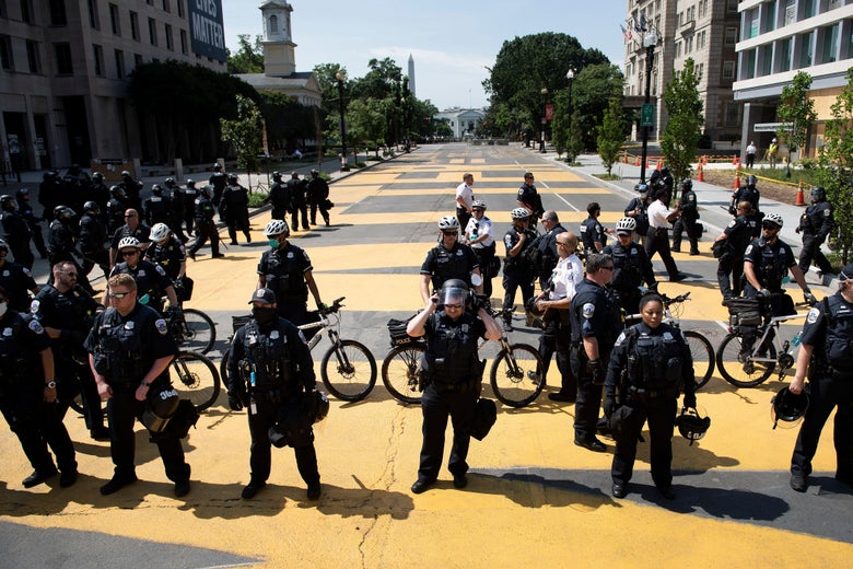Police are seen standing in a plaza.