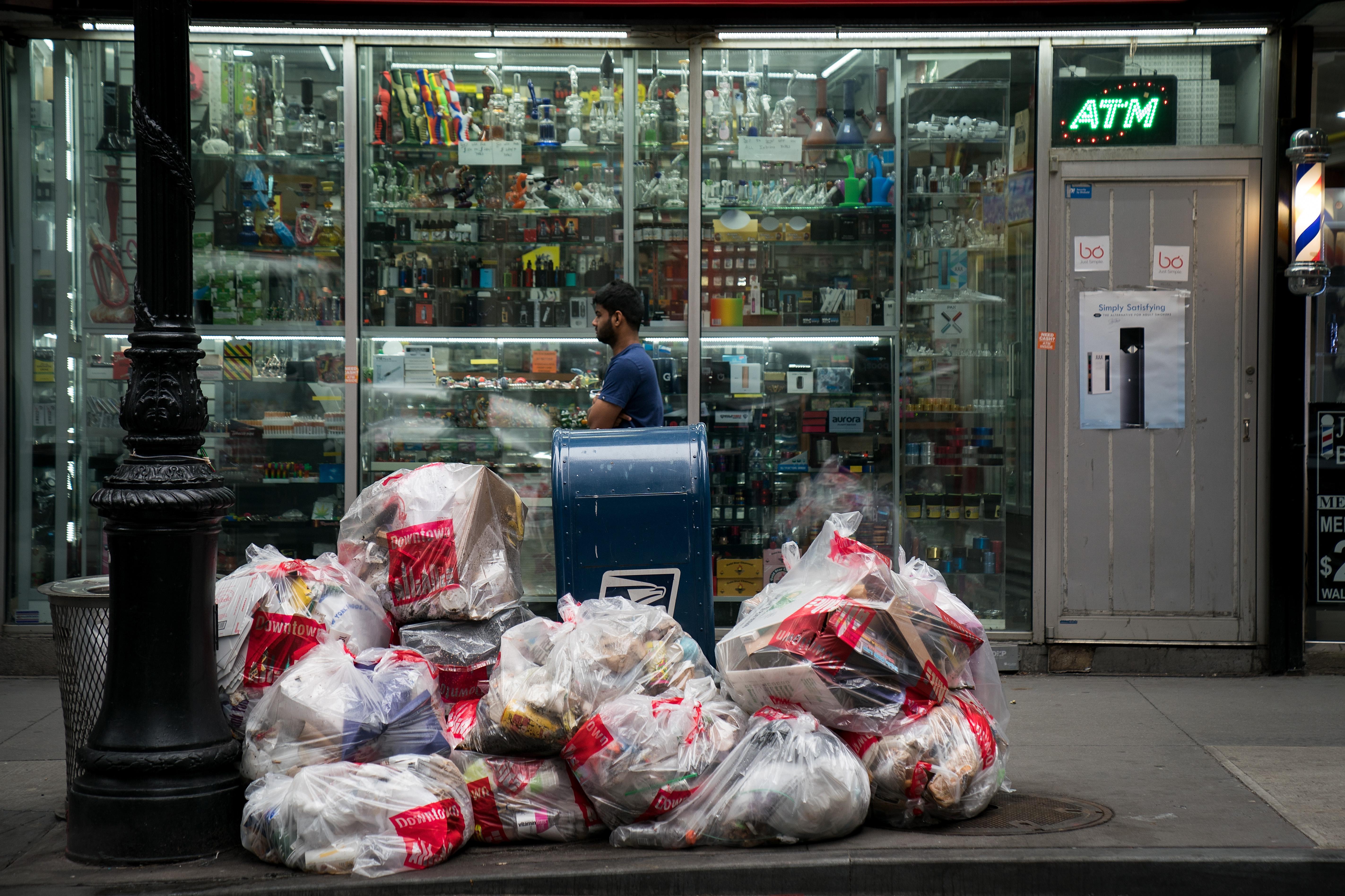 NEW YORK, NY - FEBRUARY 22: A pedestrian walks past bags of trash on a sidewalk in Lower Manhattan, February 22, 2018 in New York City. Using data from Environmental Protection Agency, the American Housing Survey and the U.S. Census Bureau, a new report from the cleaning and janitorial company BusyBee ranks New York City as the dirtiest city in the nation. (Photo by Drew Angerer/Getty Images)