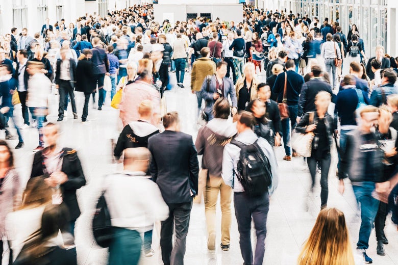 A crowd of predominantly white people with blurred faces.