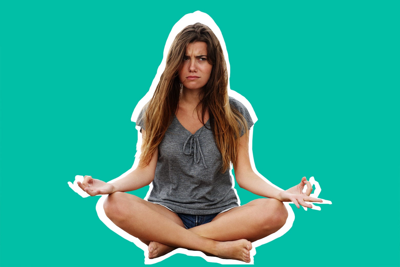 Woman with an angry face trying to meditate.