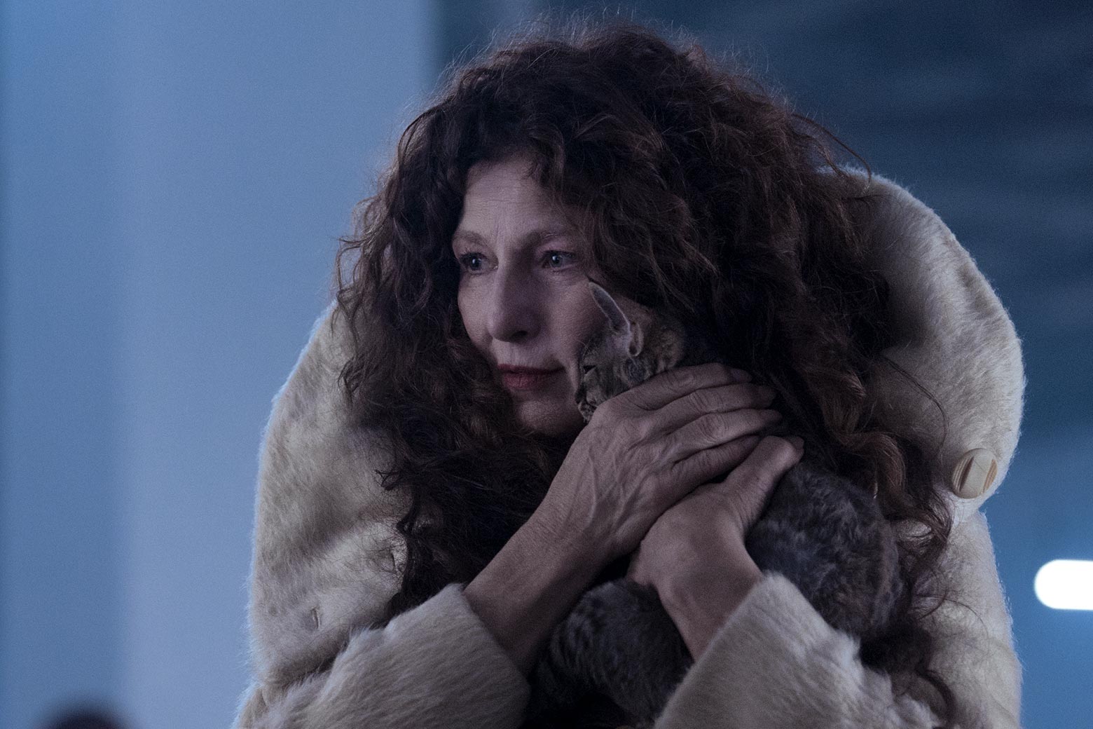 Catherine Keener, wearing a fur coat, holds a kitten to her face.