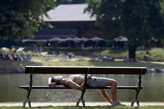 A man sleeps on a bench in a park during a heat wave in Brussels.