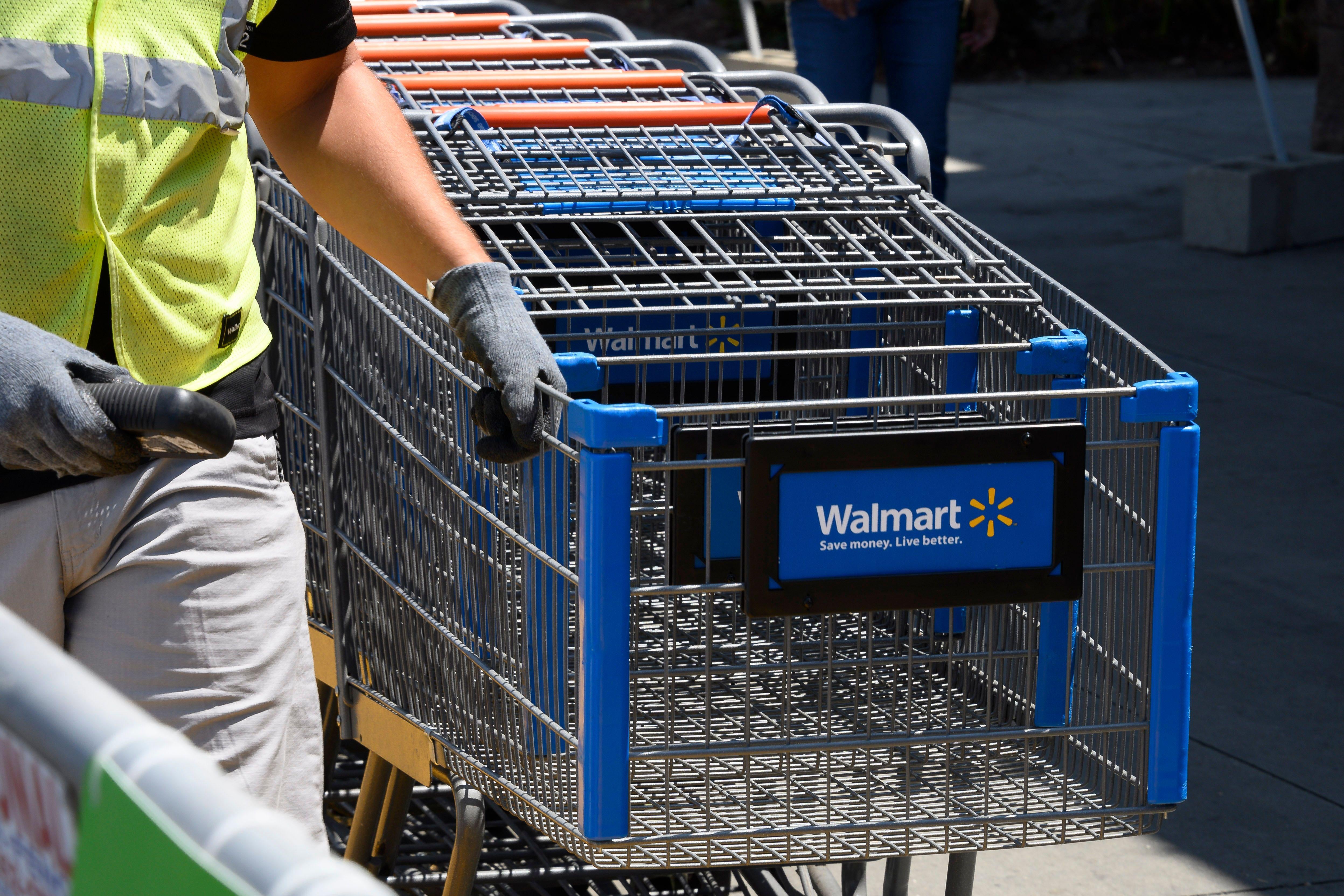 An employee gathers shopping carts