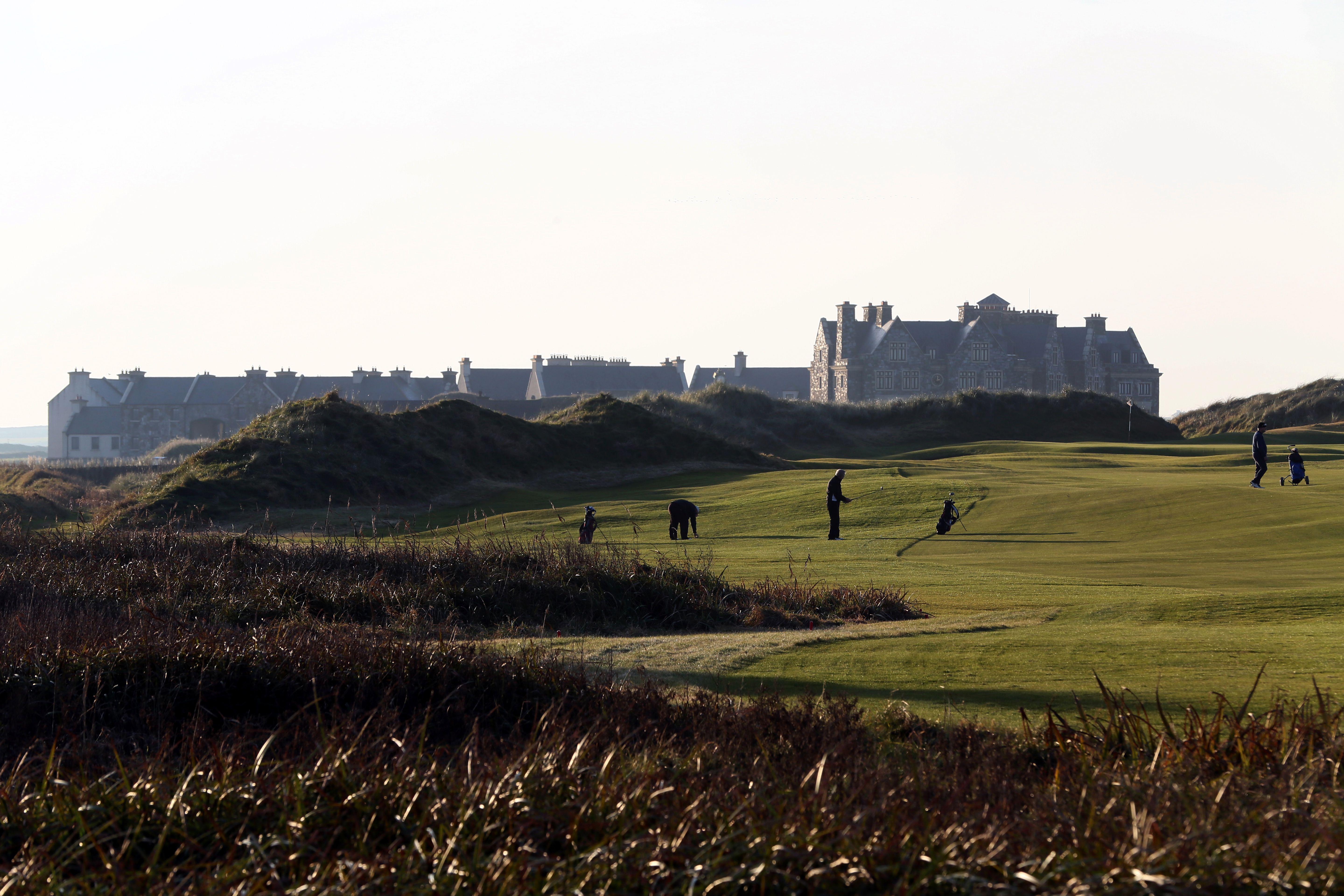 Golfers play on the fairway toward the clubhouse at Trump International Golf Course in Ireland.