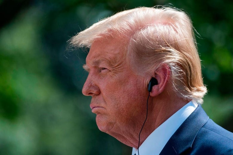 Trump, seen in close-up and in profile, frowns while he listens to a translation of Mexican President Andres Manuel Lopez Obrador via an earpiece.
