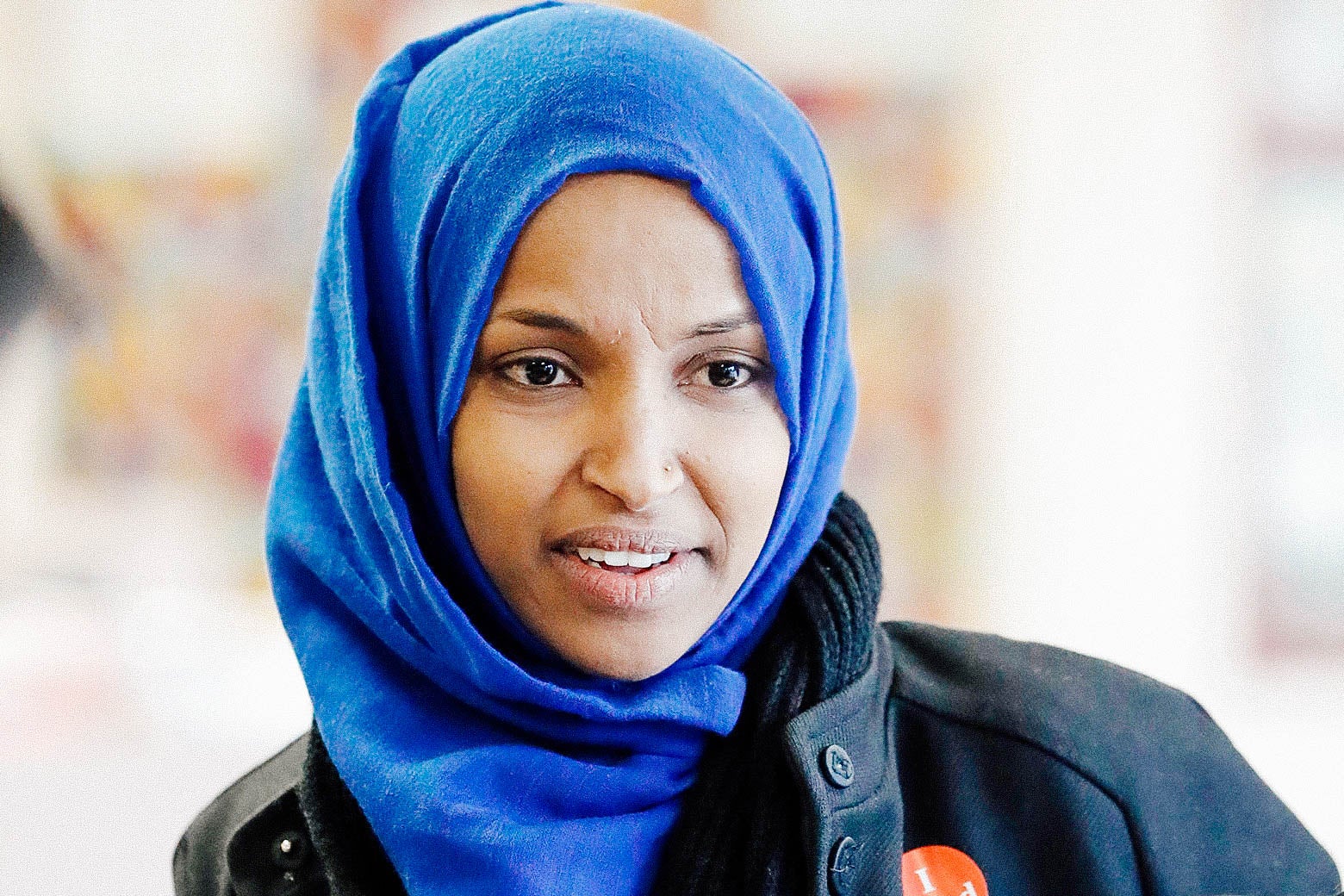 Ilhan Omar affixes a political button to her coat on Election Day in Minnesota.