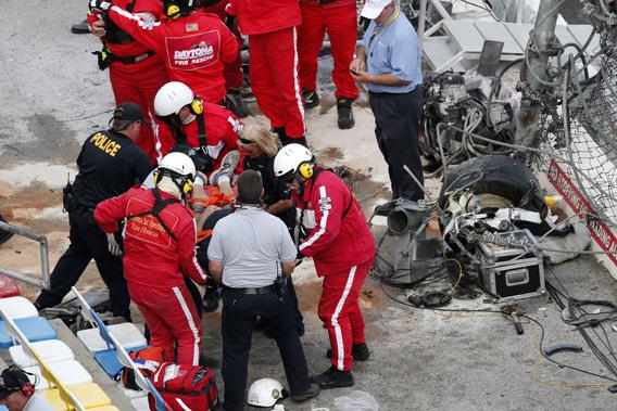 Rescue workers attend to the injured in the stands are an engine and tire (top right) are seen following a last-lap incident.